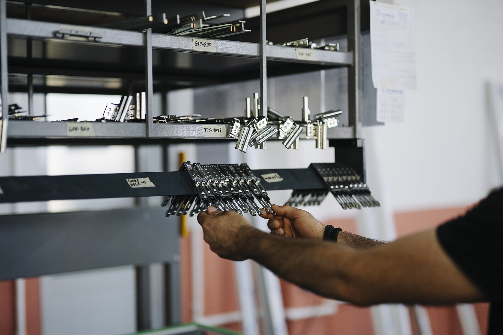 Quincaillerie de chantier : charnières et ferrures rangées en dépôt